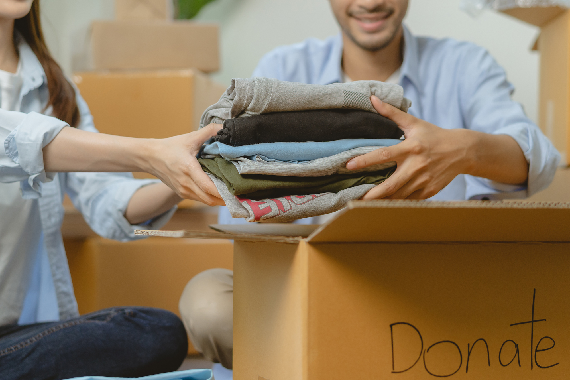 Happy volunteer asian young couple unpack, packing stuff clothes